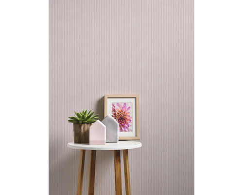 Scenă decorativă cu tapet floral, masă, plantă de interior și ramă foto