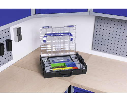 Cutie de scule deschisă cu diverse compartimente pentru șuruburi și piese mici pe un banc de lucru