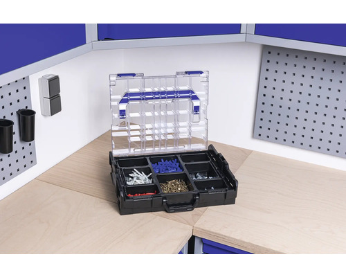 Cutie de sortiment cu șuruburi și dibluri pe un banc de lucru