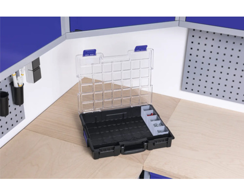 Cutie de scule deschisă cu compartimente pe un banc de lucru