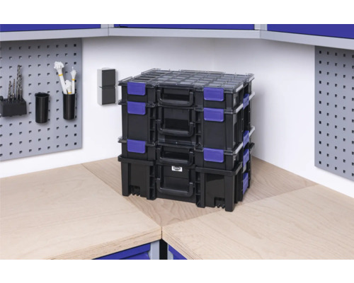 Stivă de cutii de scule negre cu închidere albastră pe un banc de lucru