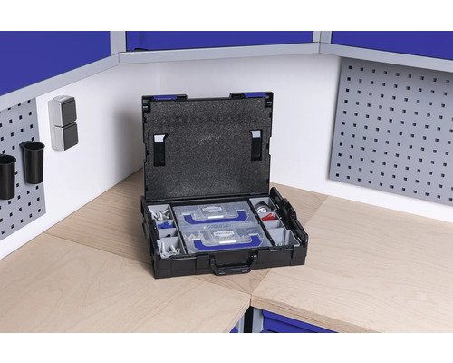 Cutie de scule deschisă cu inserții pe un banc de lucru