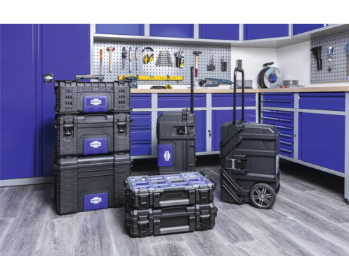 Atelier cu cutii de scule și cărucior de scule în fața unui banc de lucru cu perete pentru scule