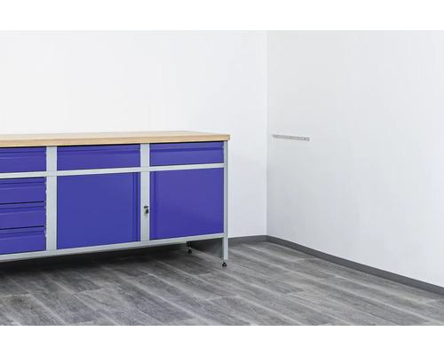 Banc de lucru cu sertare și ușă de dulap într-un atelier luminos