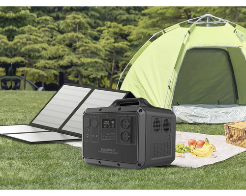 Stație de alimentare portabilă Bluepalm cu modul solar în fața unui cort pe o pajiște