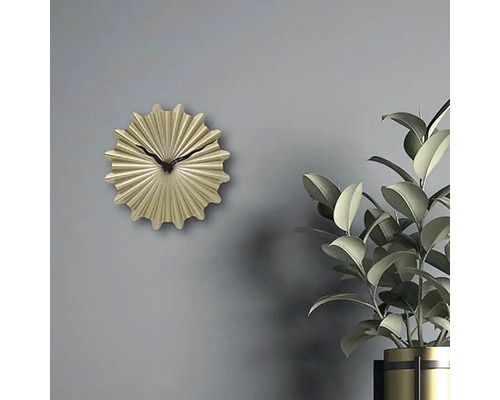 Ceas de perete decorativ auriu cu indicator negru lângă o plantă de interior