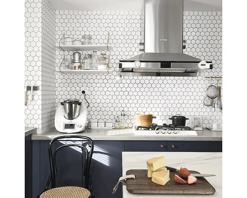 Scenă de bucătărie cu robot de bucătărie, rafturi, hotă de aragaz și plită în fața unei plăci de perete hexagonale