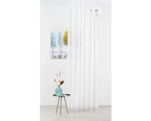 Interior decorativ cu perdea albă, tablou și vază cu flori pe o masă