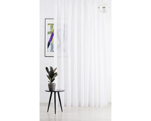 Cortină albă, transparentă, lângă o măsuță laterală și o fotografie înrămată.