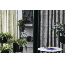 Scenă decorativă cu perdele cu model, plante și măsuță laterală
