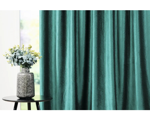 Perdea decorativă și vază cu flori pe o masă.