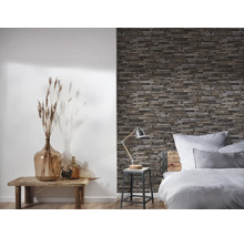 Dormitor cu tapet de perete din piatră, masă din lemn și decorațiuni