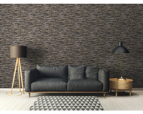 Cameră de zi cu canapea gri, lampă de podea și tapet cu aspect de piatră