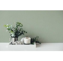 Tavă decorativă cu lumânare, plantă și decorațiuni în fața unui perete