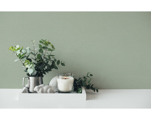 Tavă decorativă cu lumânare, plantă și decorațiuni în fața unui perete