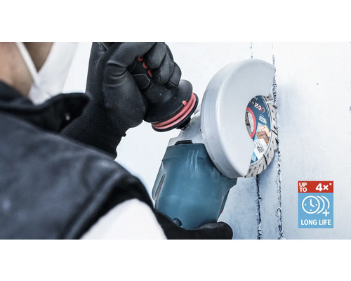 O persoană folosește un polizor unghiular pentru a tăia un perete.