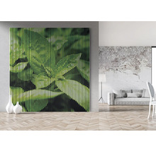 Tablou decorativ de perete cu motiv de frunze într-o cameră luminoasă.