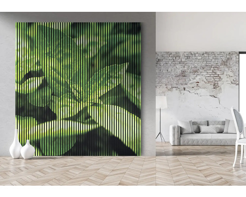 Tablou decorativ de perete cu motiv de frunze într-o cameră luminoasă.