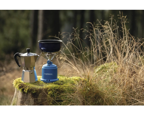 Aragaz de camping cu oală și espressor pe un ciot de copac în aer liber