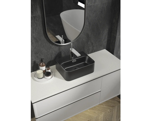 Baie modernă cu lavoar negru așezat, dulap de lavoar și oglindă