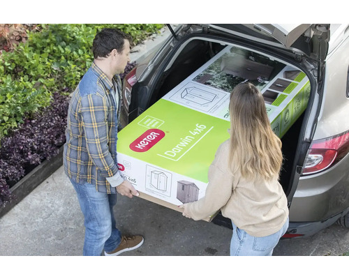 Două persoane încarcă o magazie de grădină Keter Darwin 4x6 într-o mașină.