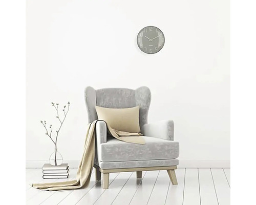 Scenă de living cu fotoliu, pernă, pătură, ceas de perete și decor