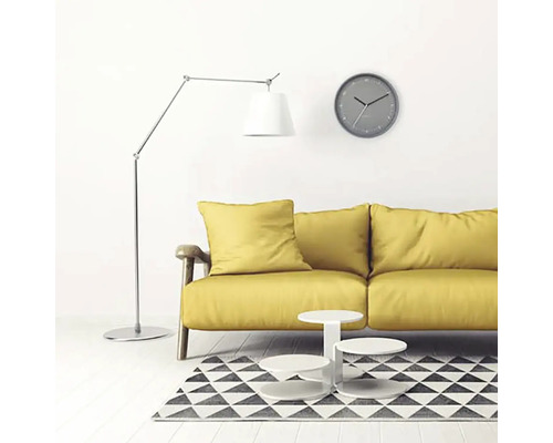 Living cu canapea galbenă, lampadar, ceas de perete și covor cu model geometric