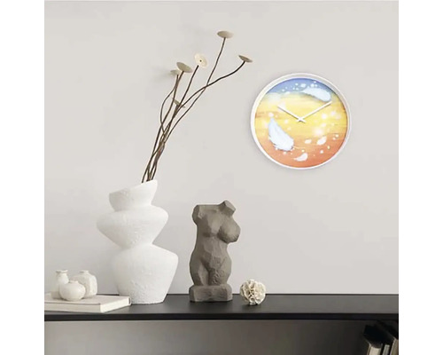 Scenă decorativă cu ceas de perete, vază, plantă și sculptură pe un raft.