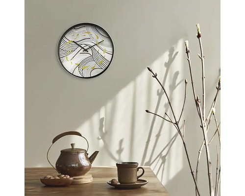Ceas de perete cu model abstract deasupra ceainicului și ceștii pe masă