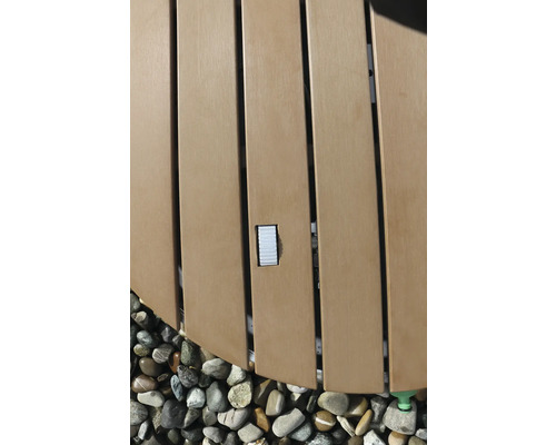 Detaliu al unui jacuzzi cu placare din lemn și pietre.