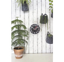 Ceas de perete cu plante pe un lambriu din lemn