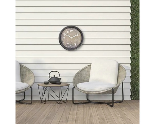 Scenă cu ceas de exterior, scaune și o măsuță cu ceainic