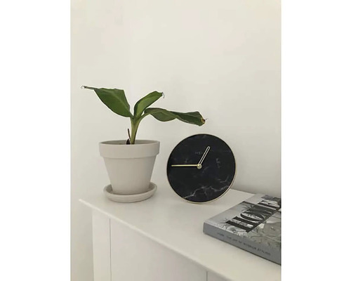 Decoratiune de masă cu plantă de apartament în ghiveci, ceas rotund și carte