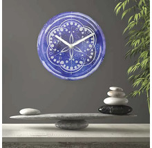 Ceas decorativ de perete cu model mandala deasupra unei grămezi de pietre