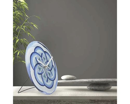 Ceas decorativ de masă cu model floral albastru pe o masă