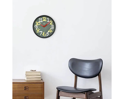 Ceas de perete cu cadran și cifre deasupra unui dulap din lemn și un scaun