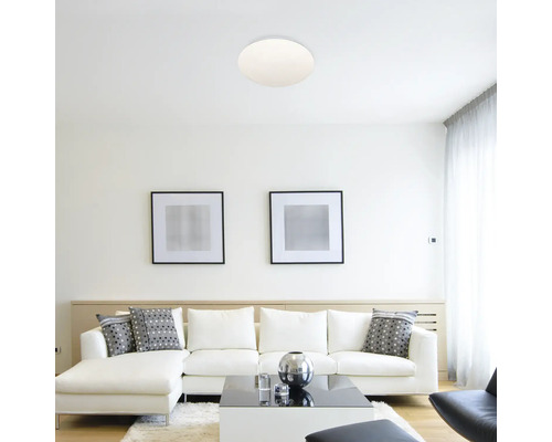 Living luminos cu plafonieră rotundă și canapea albă