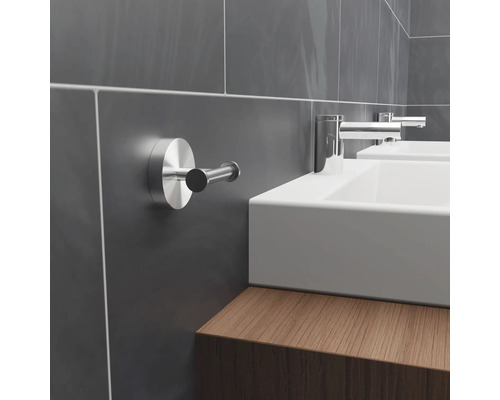 Baie modernă cu pereți cu faianță gri, chiuvete și cârlig pentru prosoape.