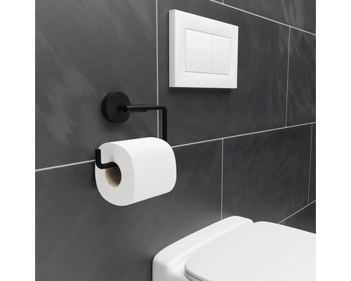 Suport metalic pentru hârtie igienică cu rolă de hârtie igienică lângă un rezervor de toaletă