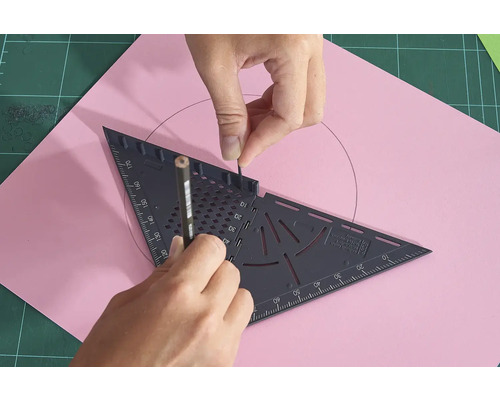 O persoană desenează un cerc pe o foaie de hârtie roz cu un creion și un triunghi.