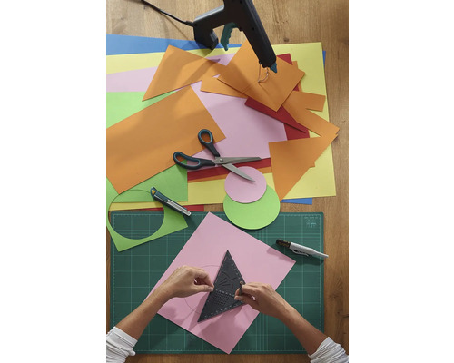 Scenă de artizanat cu hârtie, foarfece, pistol de lipit și suport de tăiere