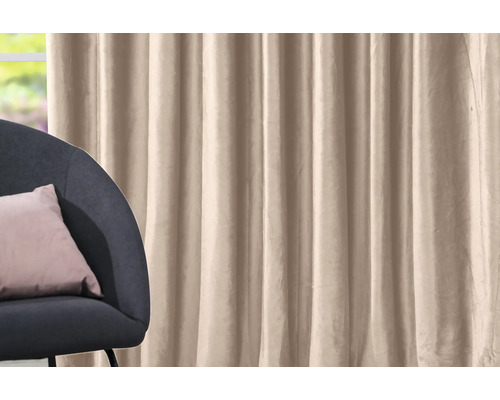 Perdea bej lângă un fotoliu cu pernă.