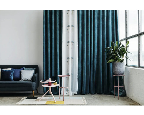 Sufragerie cu canapea, măsuțe laterale, plantă de interior și perdele