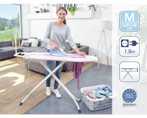 Femeie călcând rufe pe o masă de călcat Leifheit, coș de rufe cu rufe