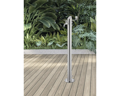 Duș de grădină din oțel inoxidabil pe terasă de lemn, în fața unei vegetații luxuriante