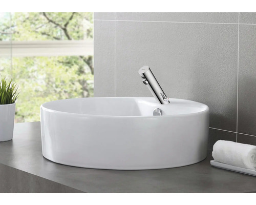 Lavoar ceramic pe blat cu baterie într-o baie.