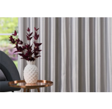 Scenă decorativă cu perdele, măsuță laterală, fotoliu și vază cu ramuri decorative