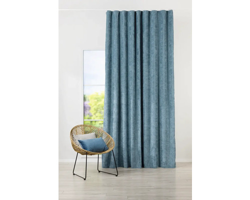 Fotografie de interior a unui living cu o perdea albastră și un scaun din ratan