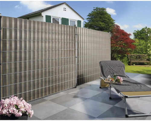 Grădină cu paravan de confidențialitate, șezlong și casă în fundal