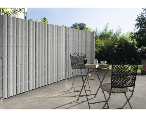 Gard de confidențialitate din plastic cu masă și scaune pe o terasă